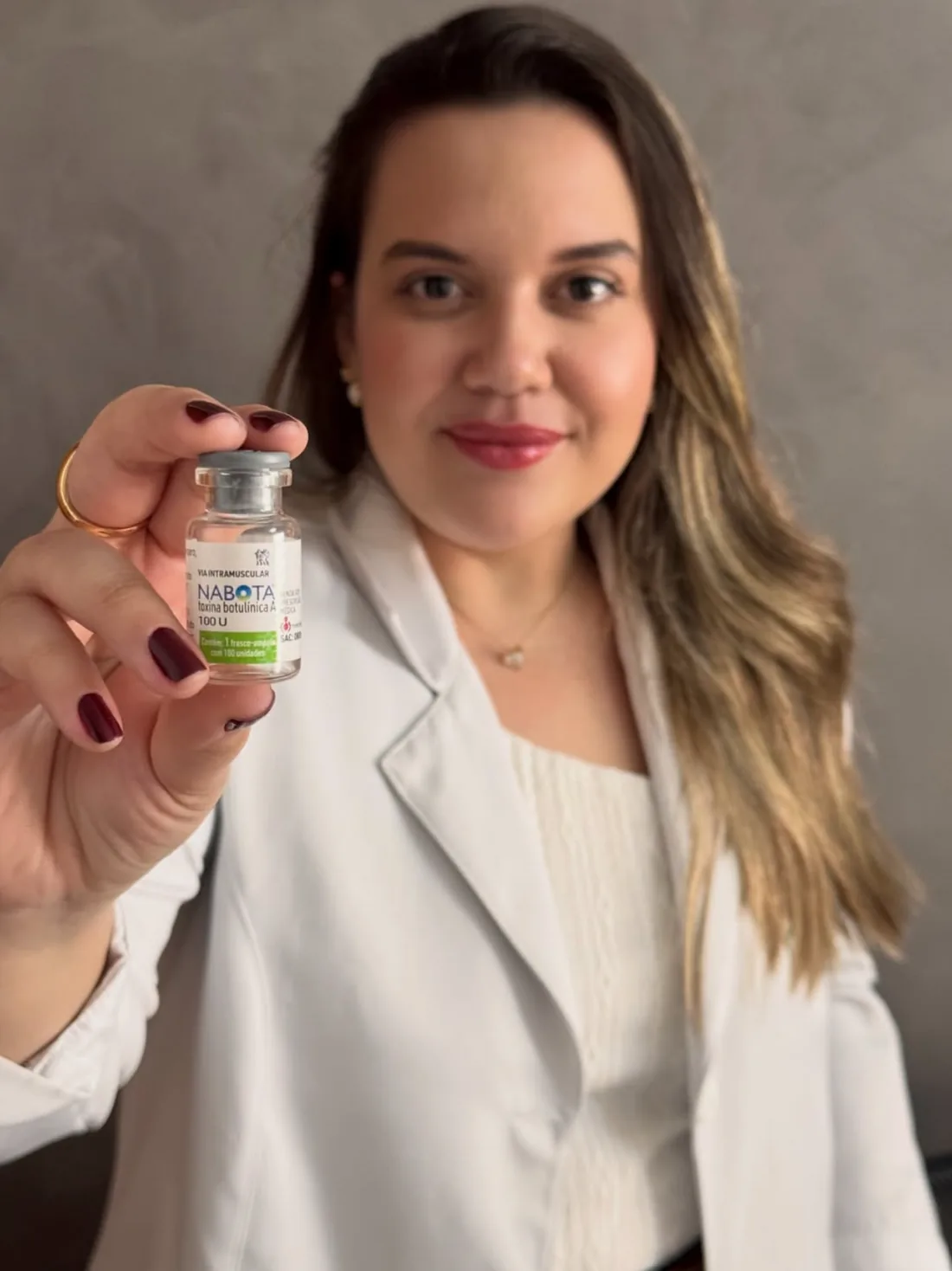 Dra. Giovana Souza segurando produto para procedimento estético